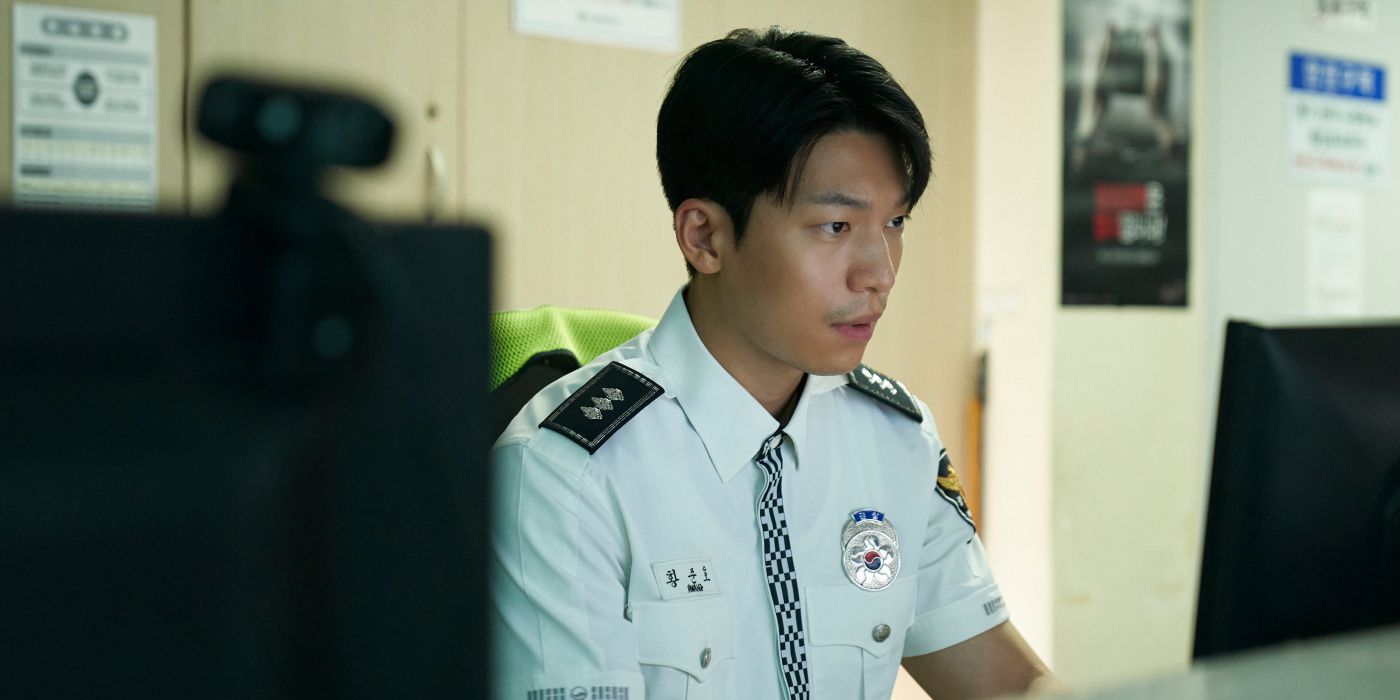 Hwang Jun-ho (Wi Ha-joon) wearing his traffic cop uniform while working on a computer in Squid Game Season 2