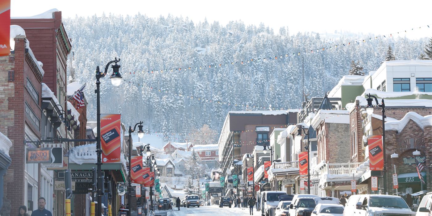 Snow, cars and people on Salt Lake City's Main Street with a view of the mountains at Sundance Film Festival