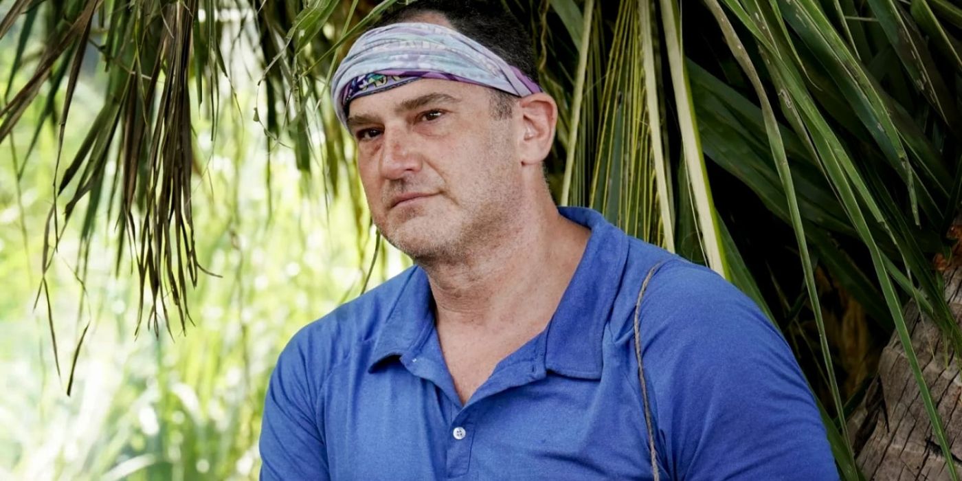 Dan Spilo in front of jungle foliage looking deep in thought on &lsquo;Survivor: Island of the Idols.'
