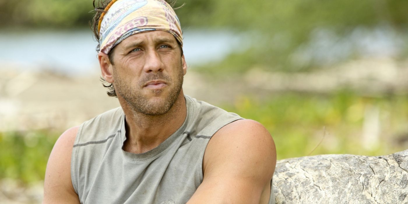 John Rocker sits next to a rock and looks past the camera on &lsquo;Survivor: San Juan del Sur.'