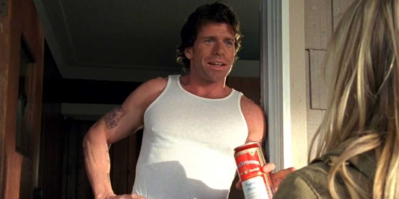 Taylor Sheridan as Danny in a white tank top holding a beer in a doorway talking to someone in Veronica Mars.