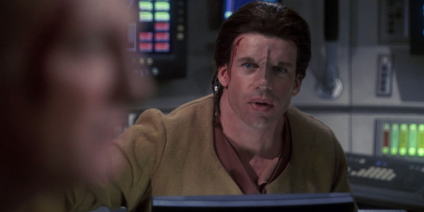 Taylor Sheridan as Jareb talks to someone closer from behind a computer in Star Trek Enterprise.