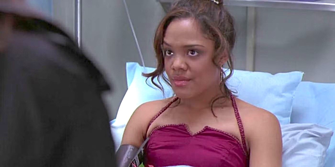 Tessa Thompson as Camille Travis in an evening gown in a hospital bed, looking serious in Grey's Anatomy.