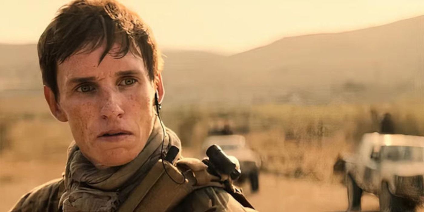 Eddie Redmayne as The Jackal stands in the desert dressed in a military uniform in The Day of the Jackal.