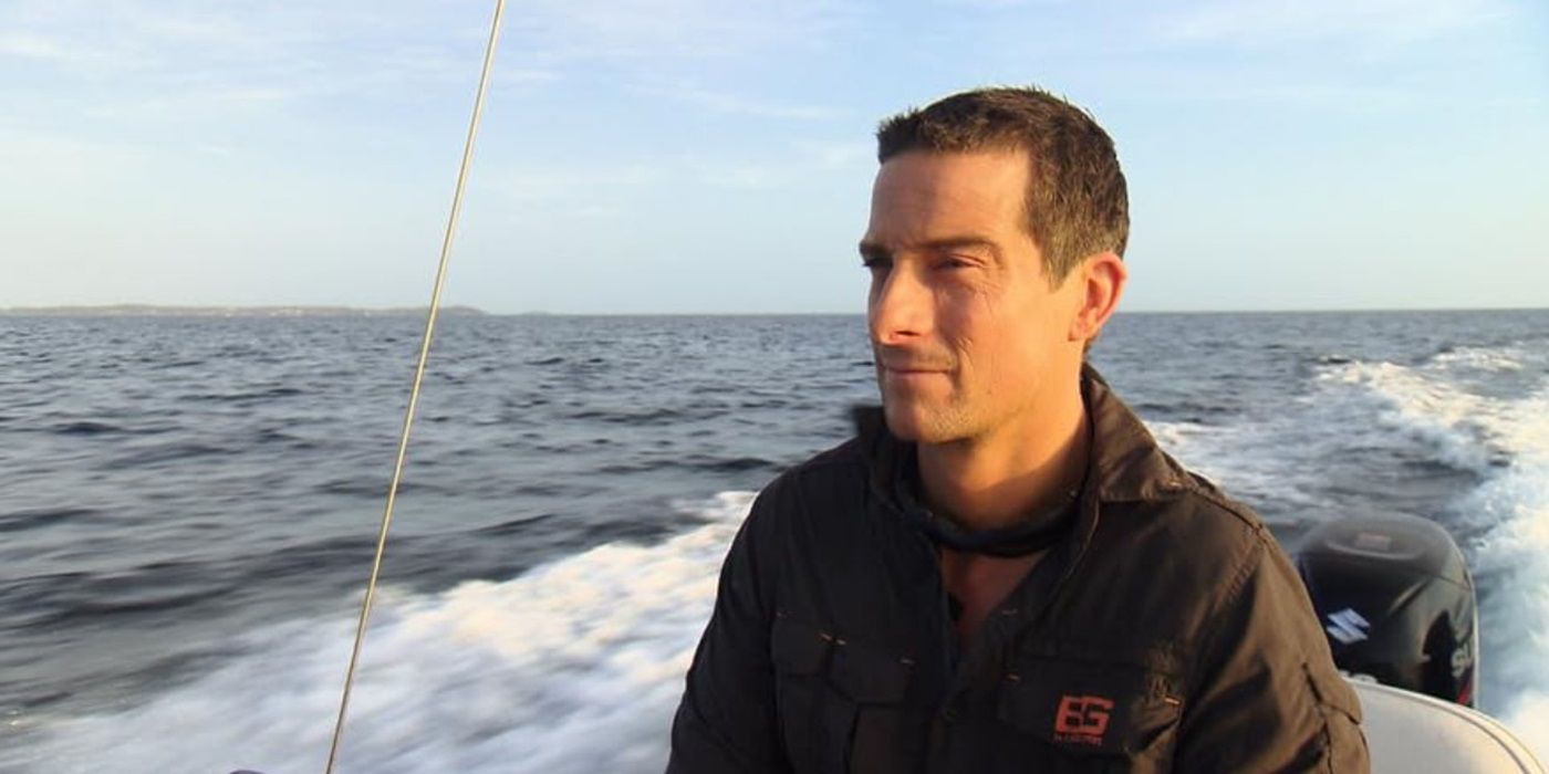 Bear Grylls stares ahead on a boat speeding through water on The Island.
