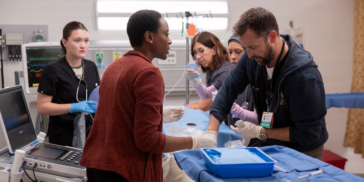 Dr. Collins (Tracy Ifeachor) and Dr. Robby (Noah Wyle) standing on opposite sides of a patient lying on a gurney in The Pitt