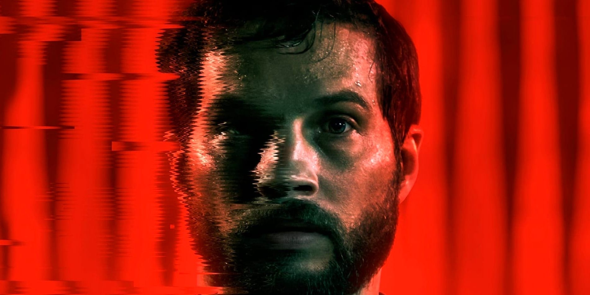 Grey, played by actor Logan Marshall-Green, stands against a red light backdrop while his face blurs on the poster for Upgrade.