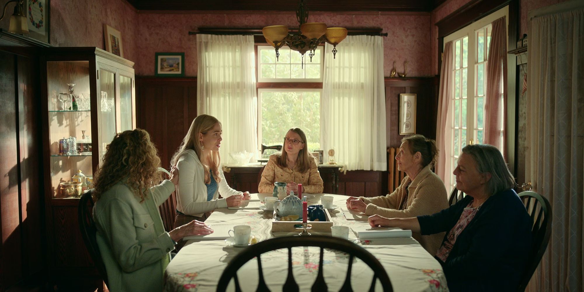 A group of women sit around a table in a dining room in Virgin River season 5.