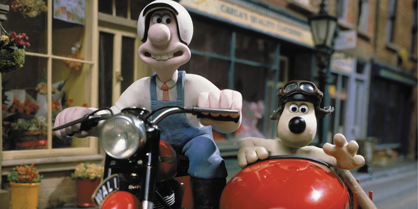 Wallace and Gromit in on a motorcycle riding through a town square