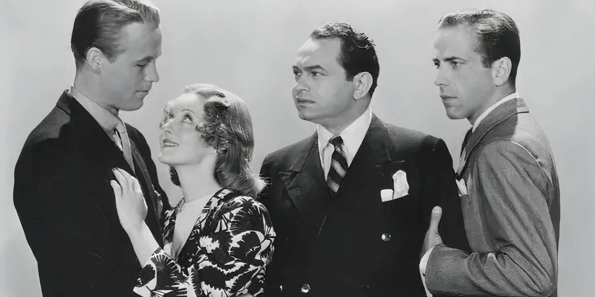 Wayne Morris and Bette Davis embracing with Edward G. Robinson and Humphrey Bogart standing behind her looking at them in a promo shot for Kid Galahad (1937)