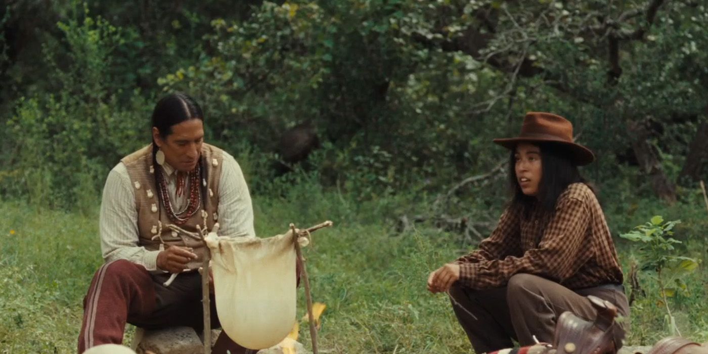 Aminah Nieves and Michael Spears sitting by a campfire