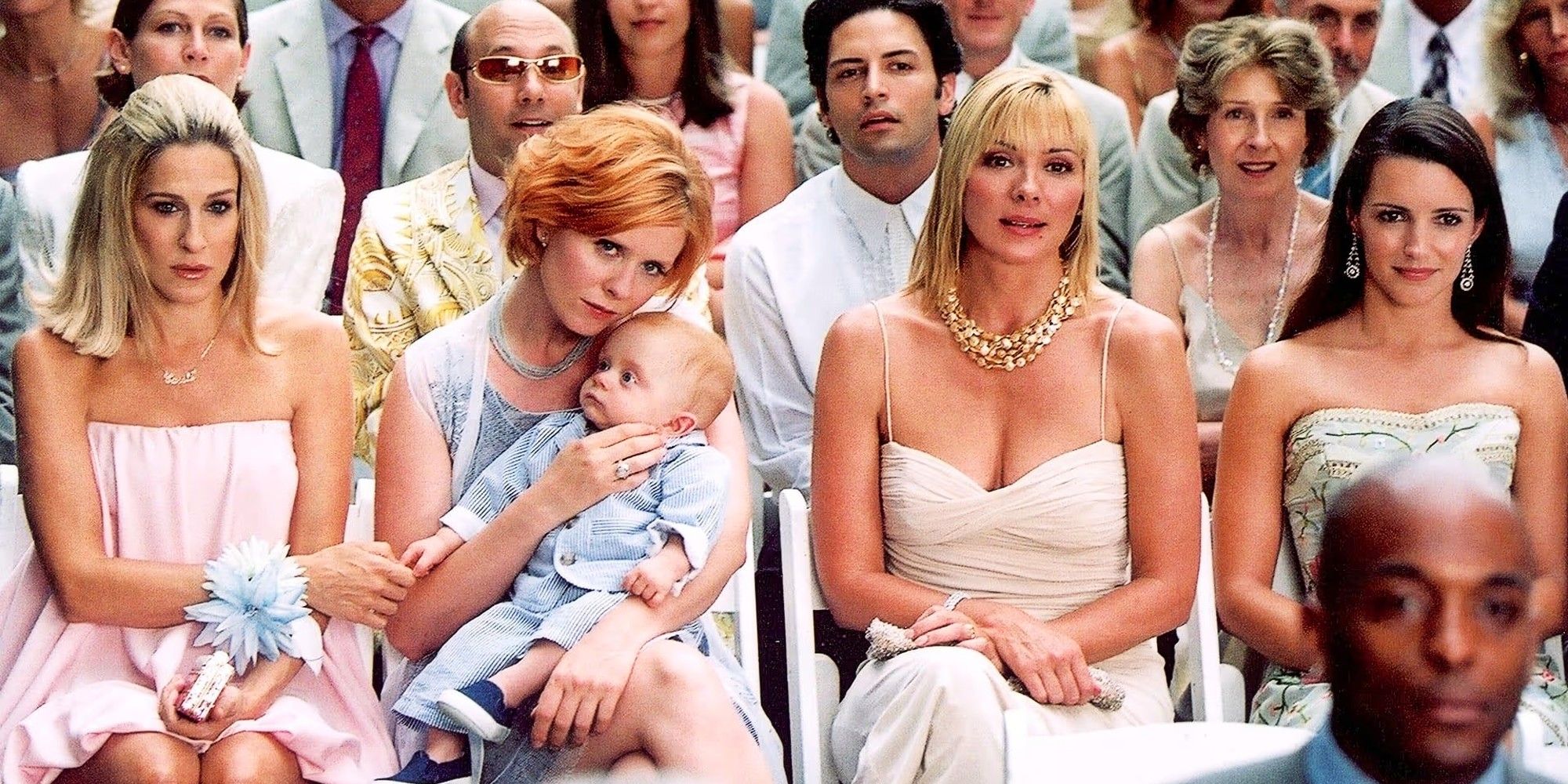 Carrie, Miranda, Brady, Samantha, and Charlotte sitting at a wedding in Sex and the City Season 5