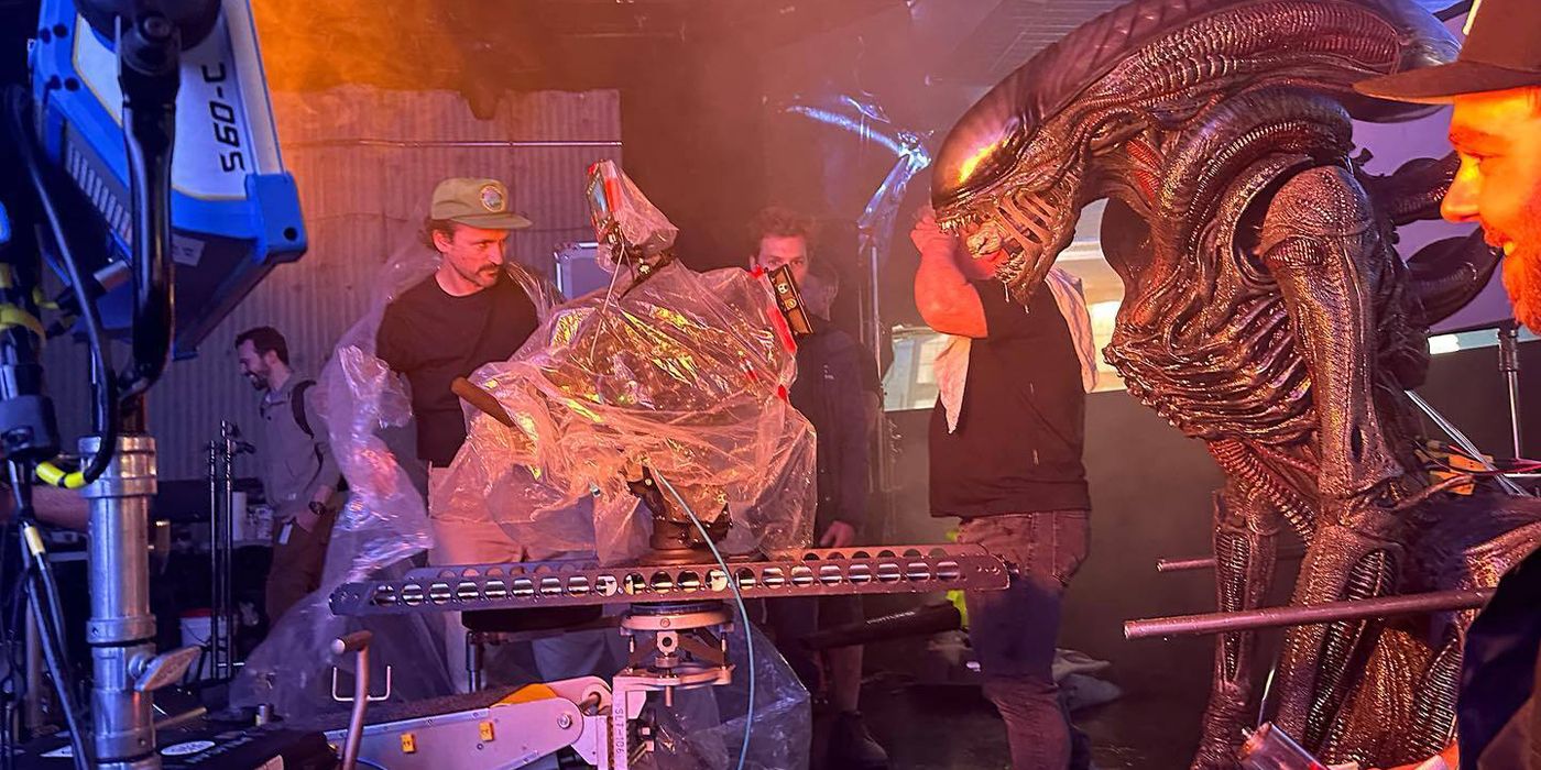 Behind-the-scenes image of crew members and a practical Xenomorph on Alien: Romulus