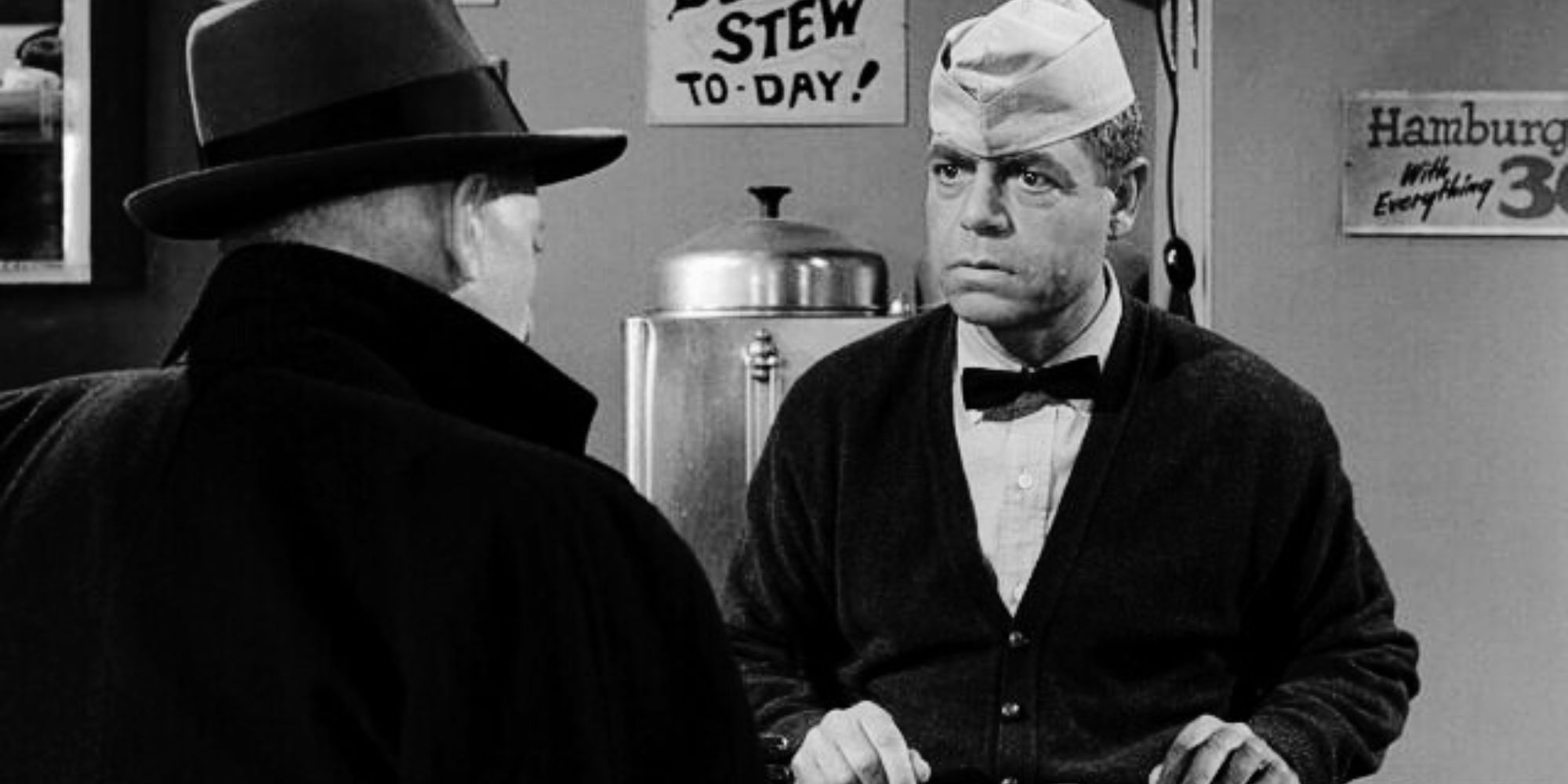 Barney Phillips standing behind a diner counter looking at a man seated across from him in The Twilight Zone episode Will the Real Martian Please Stand Up
