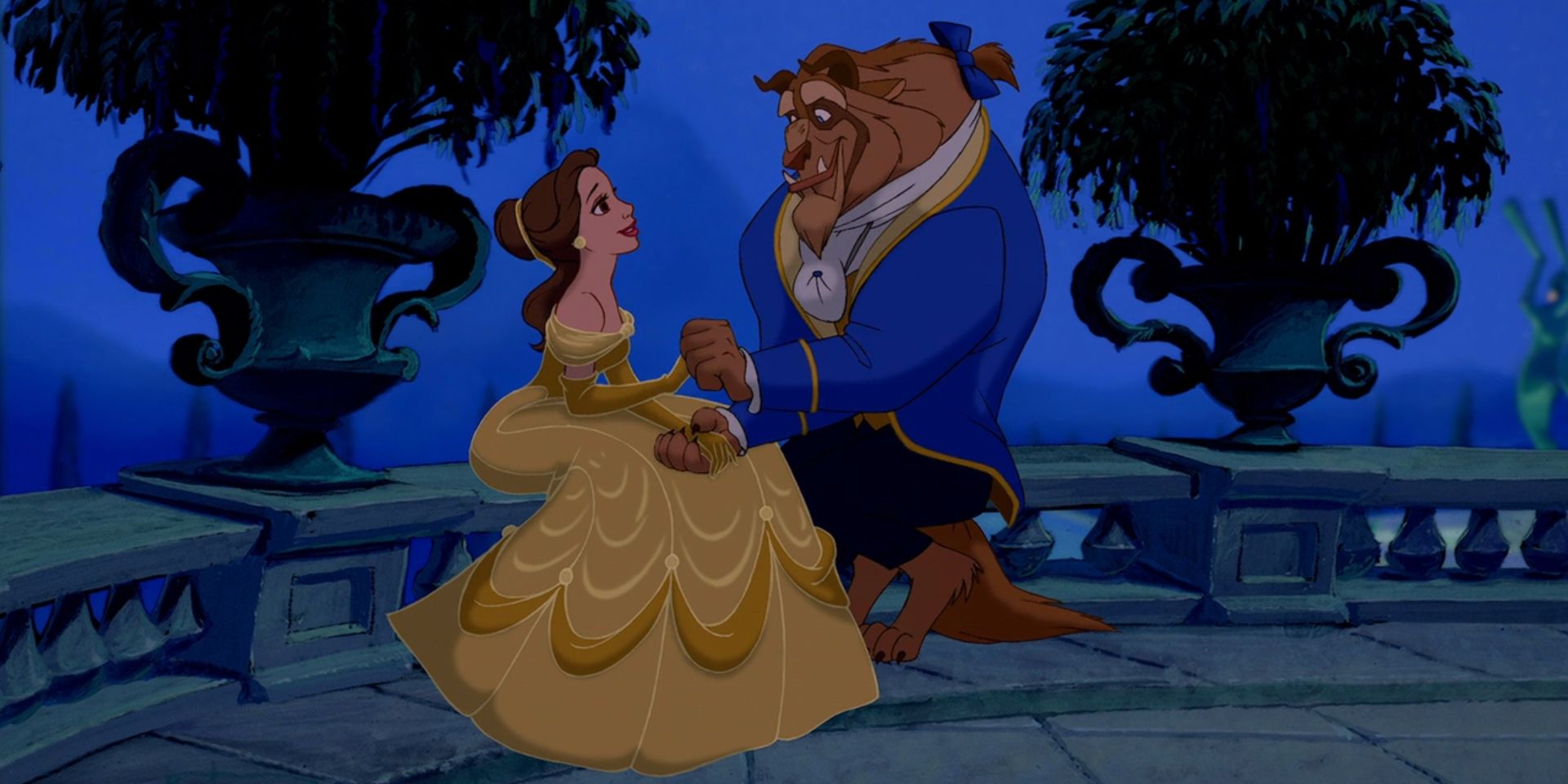 The Beast (Robby Benson) holds Belle's (Paige O'Hara) hand as they sit outside in 'Beauty and the Beast'.