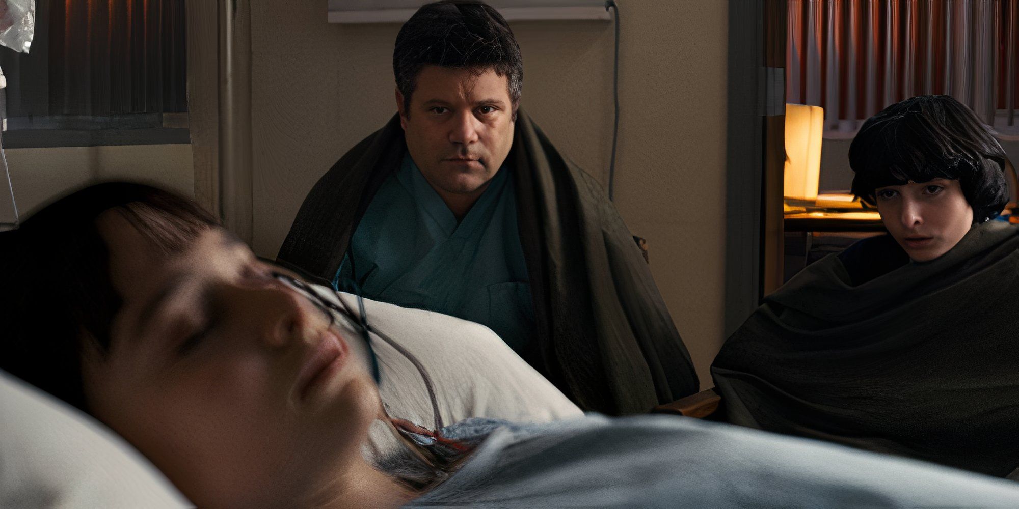 Bill and Mike looking at Noah Schnapp&rsquo;s Will in as he lies on an hospital bed in Stranger Things