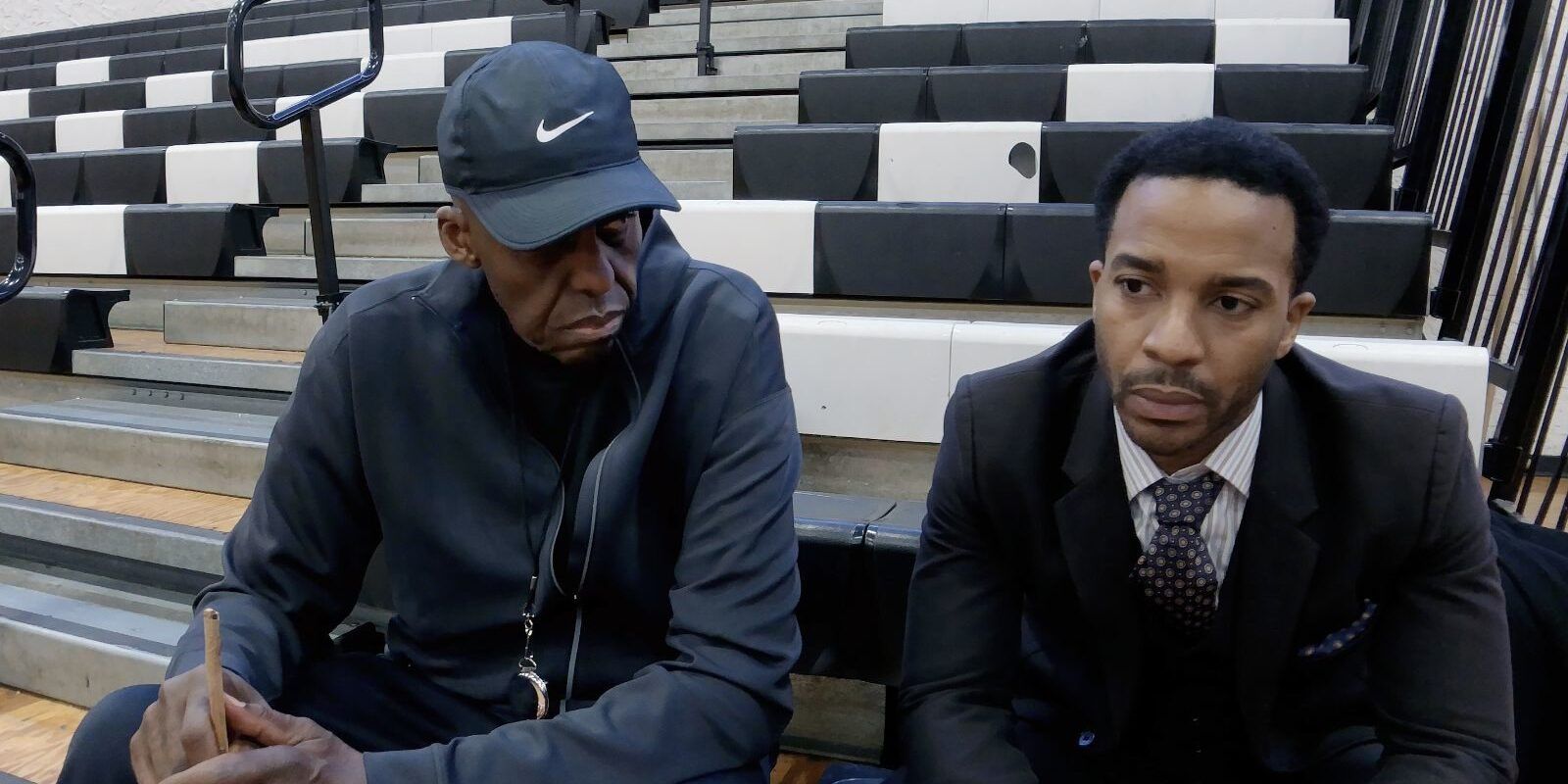 Bill Duke and Andre Holland sit on bleachers and look serious in 'High Flying Bird'.