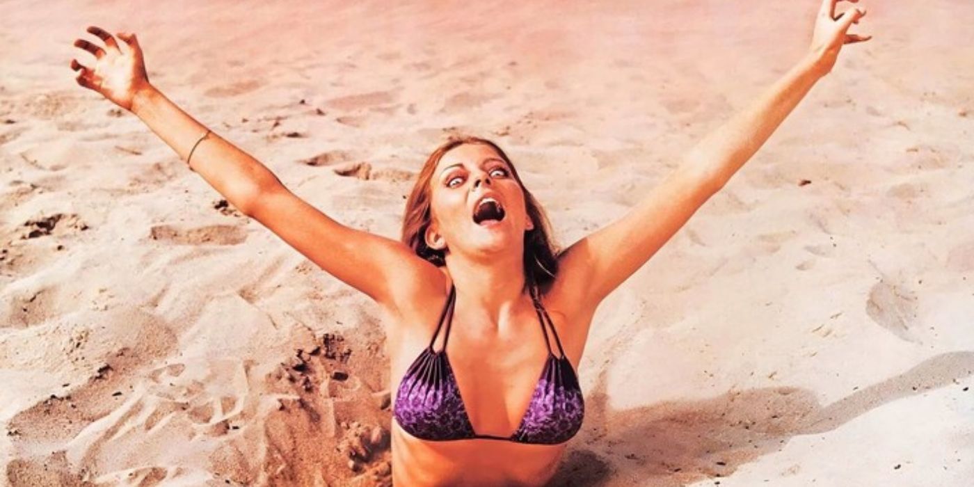 A woman trapped in the sand in the film Blood Beach 1980