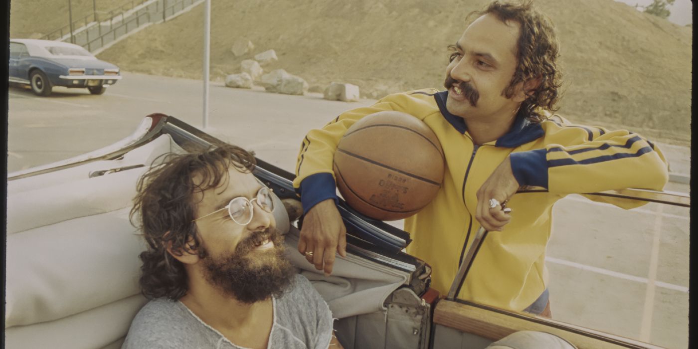 Cheech Marin holding a basketball and leaning against a car with Tommy Chong in Cheech and Chong's Last Movie