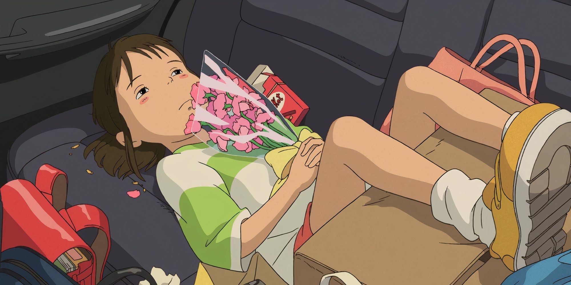 Chihiro holding a bouquet of flowers while lying down on the car in Spirited Away