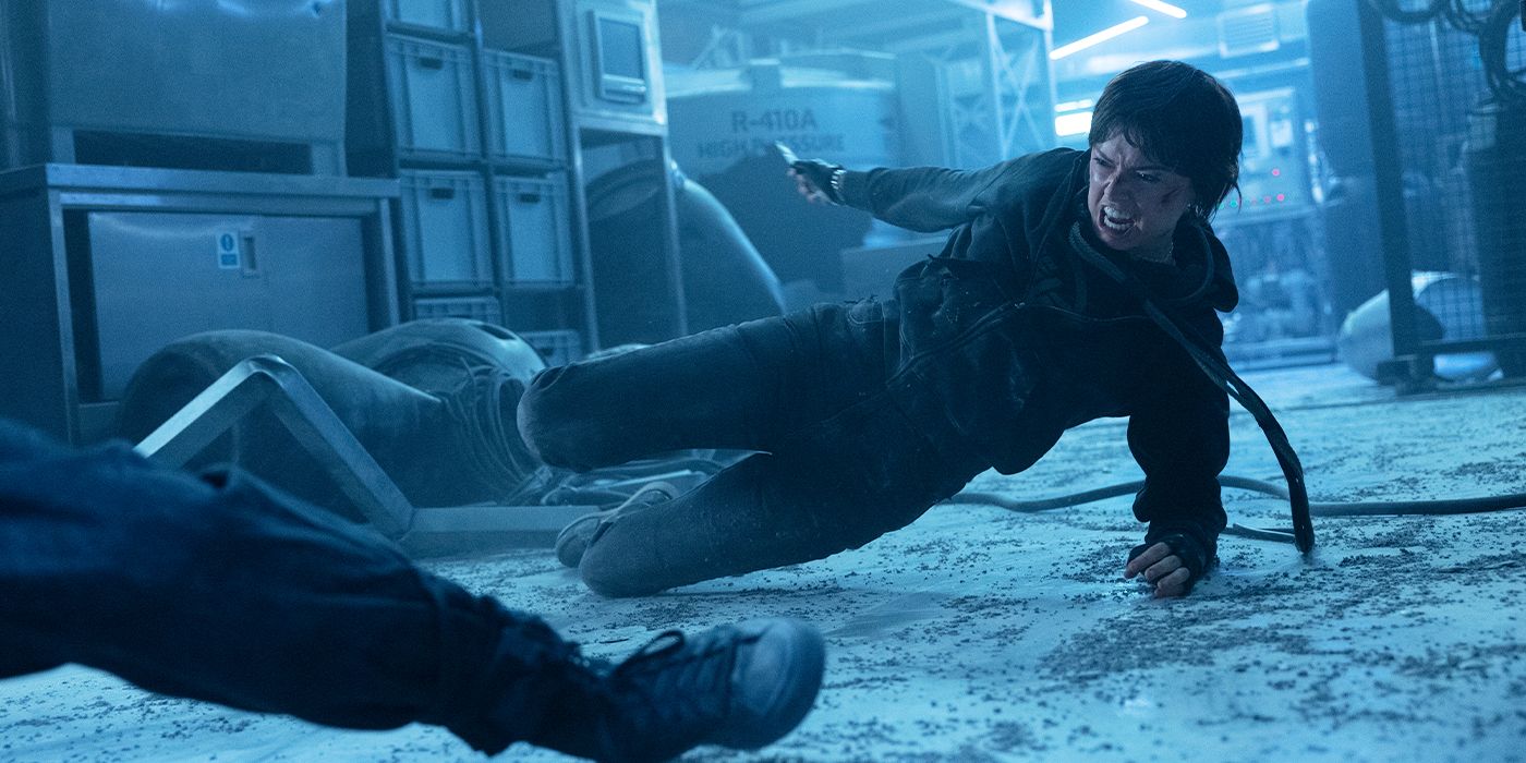 Joey (Daisy Ridley) sliding towards someone on the ground mid-fight in Cleaner