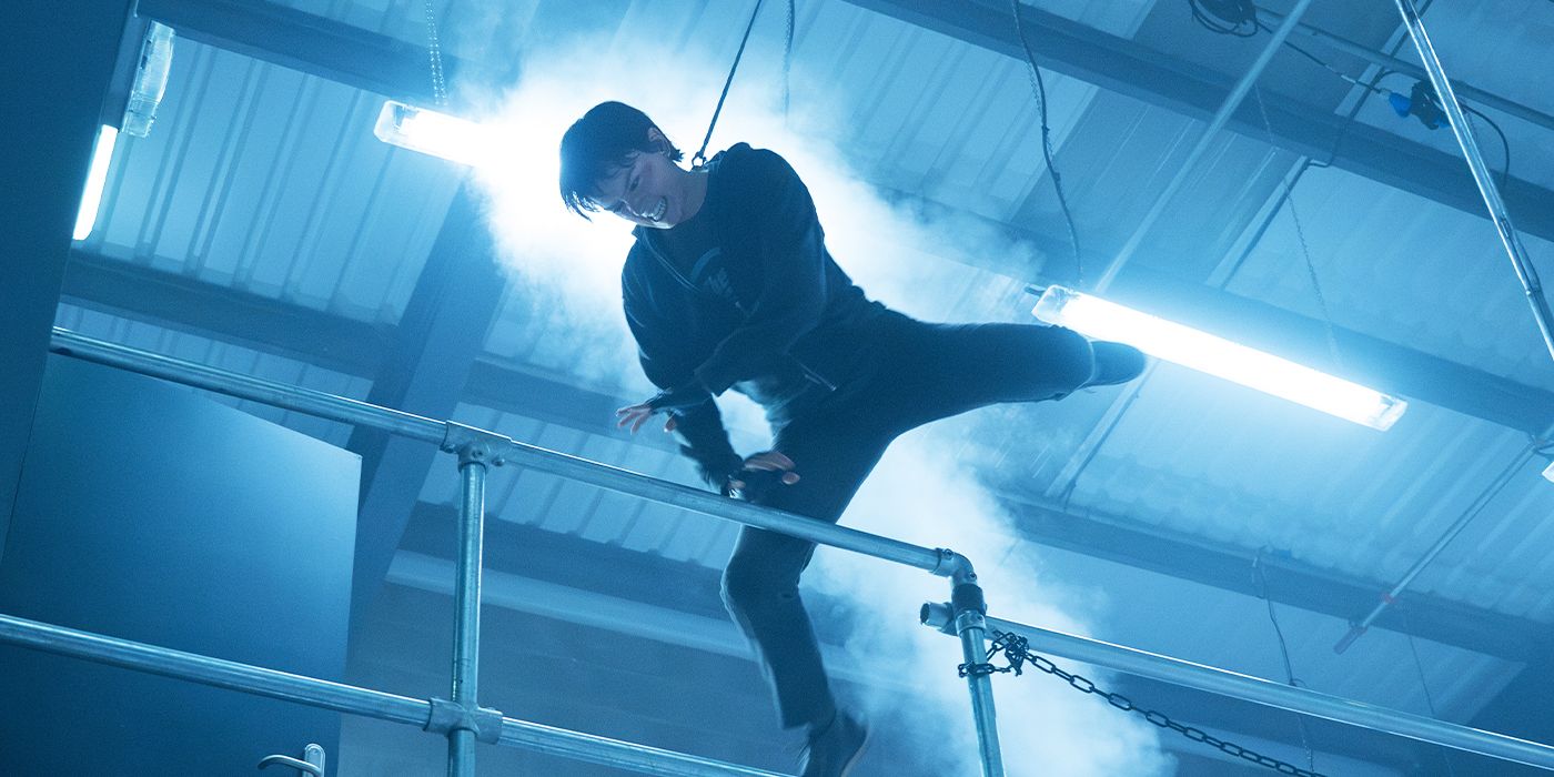 Daisy Ridley strapped to a wire performing stunt work on the set of Cleaner