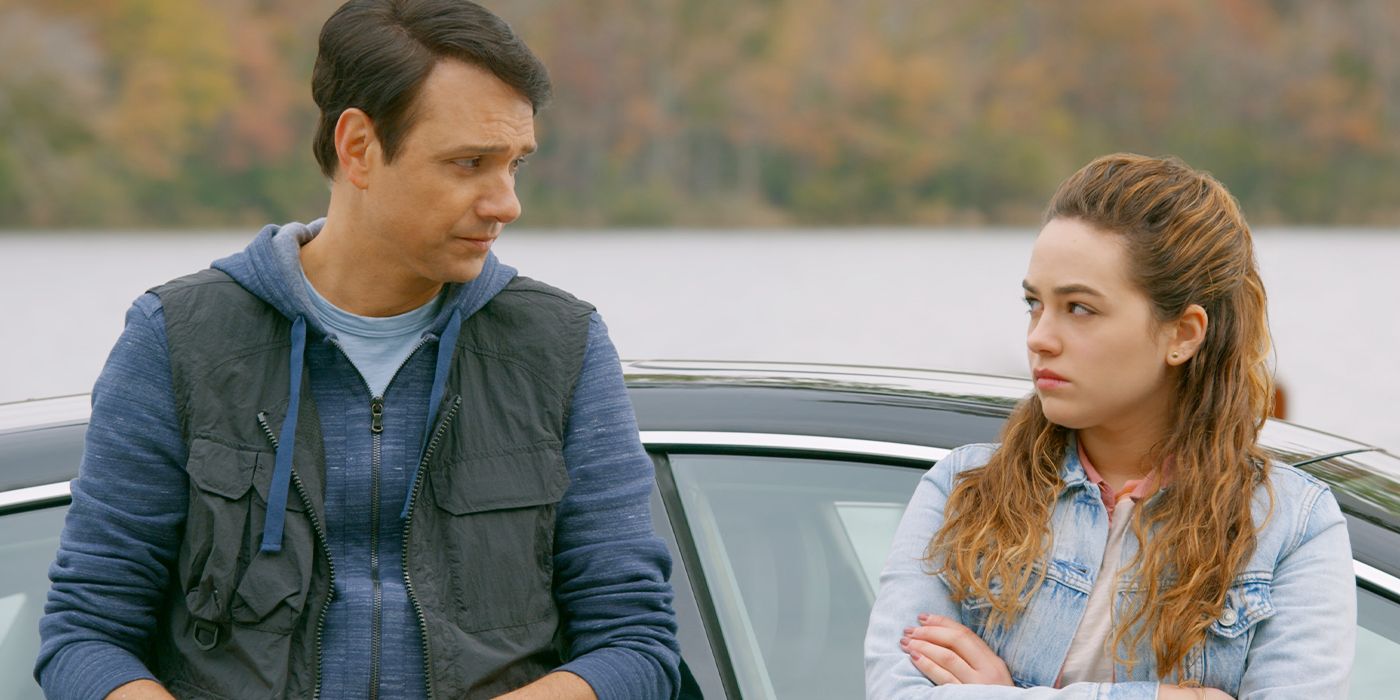 Ralph Macchio and Mary Mouser as Daniel and Sam LaRusso leaning against a car talking in Cobra Kai