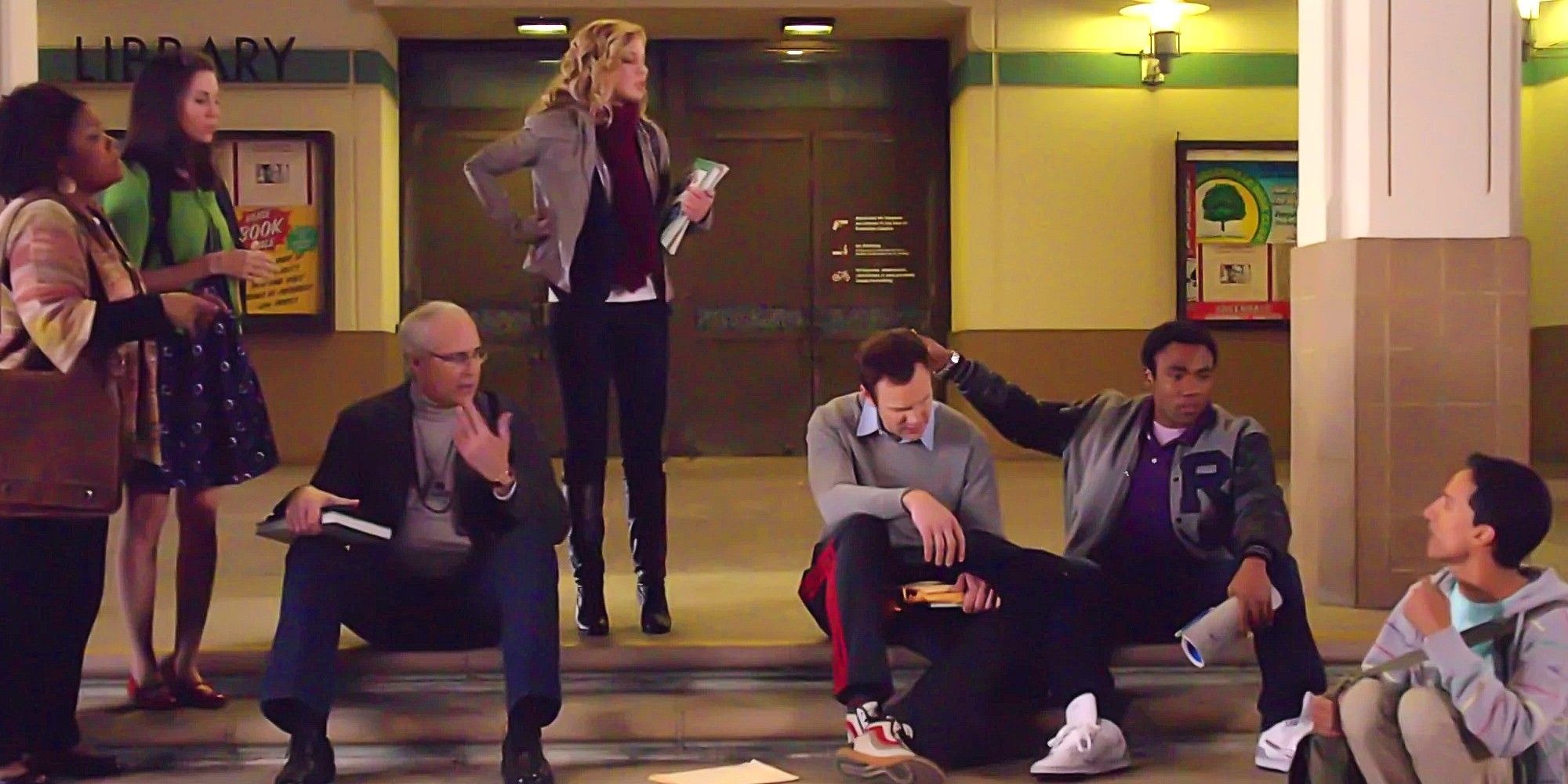 Shirley Bennett, Annie Edison, Pierce Hawthorne, Britta Perry, Jeff Winger, Troy Barnes, and Abed Nadir huddled together outside the library in the pilot episode of Community