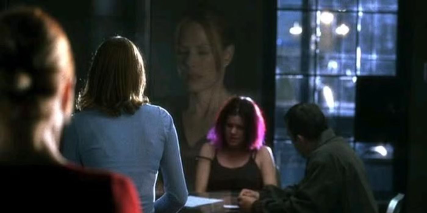 A young woman with purple hair sits with people on the other side of two-way glass as an agent looks on in CSI.