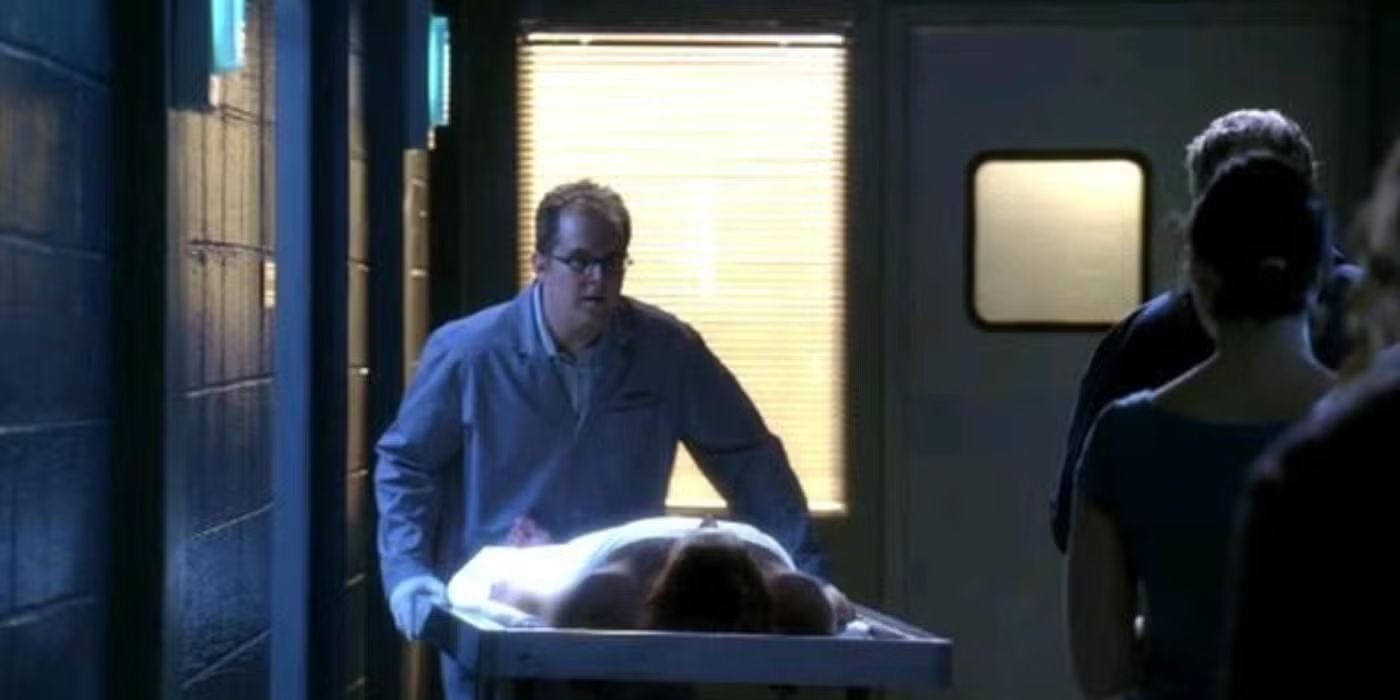 A mortician wheels a body past others in a hallway in CSI episode Toe Tags.