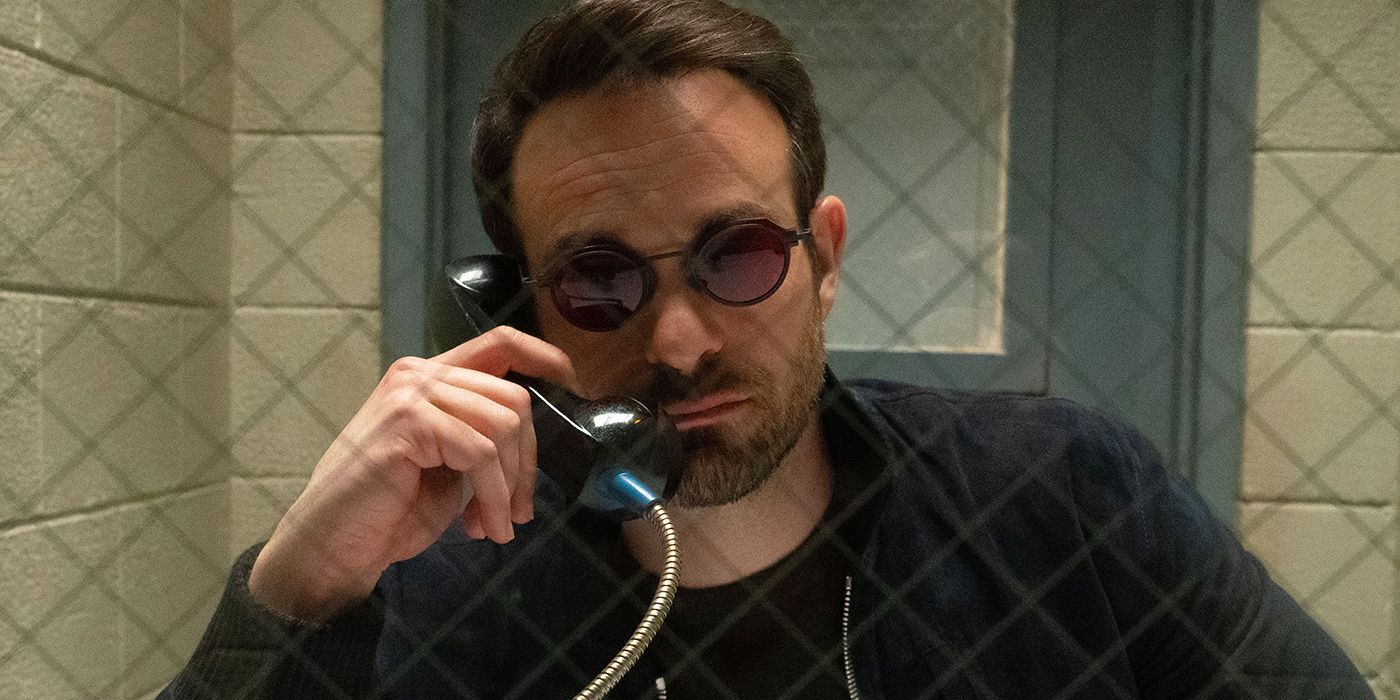 Charlie Cox as Matt Murdock talking on a prison phone and looking through the divider window in Daredevil: Born Again