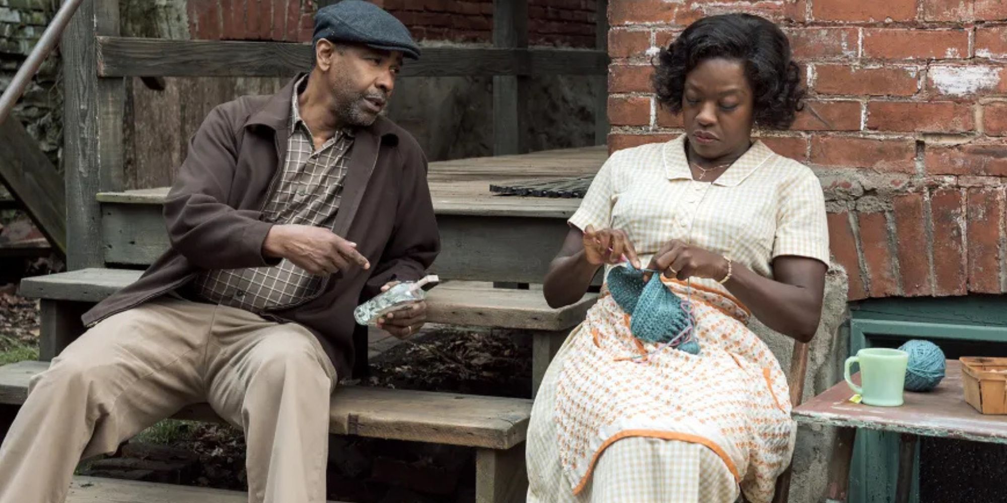 Denzel Washington sitting on wooden steps next to Viola Davis sitting next to him in Fences (2016)