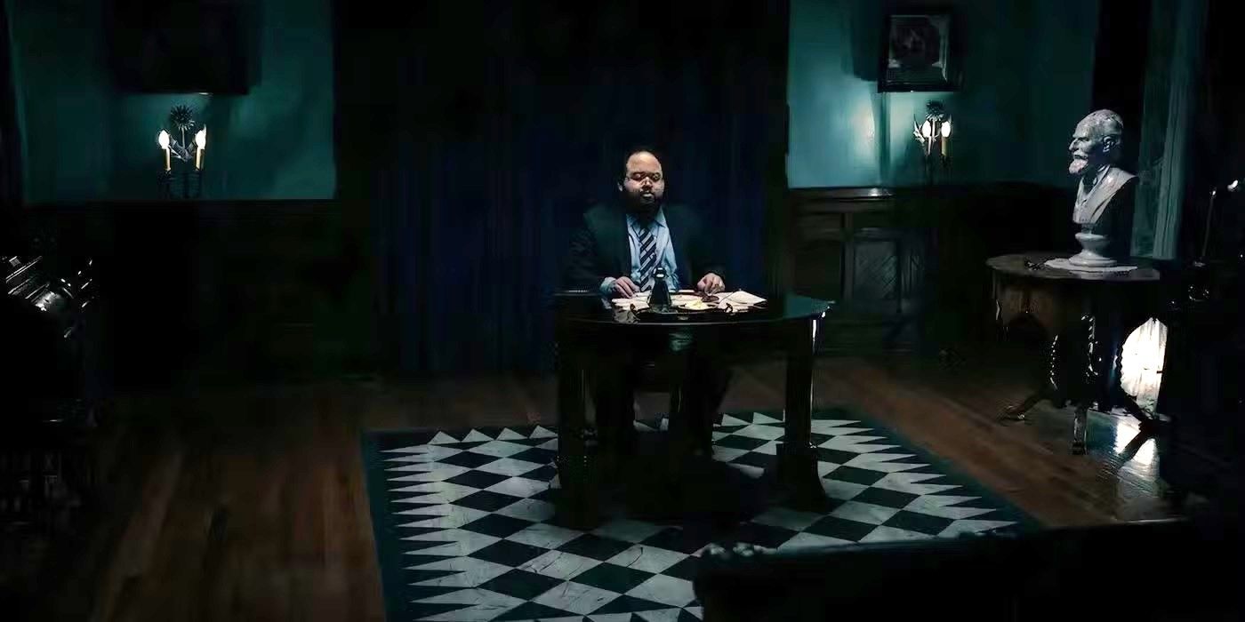 Zach Cherry as Dylan sitting alone in a fancy room enjoying a Waffle Party in Severance.