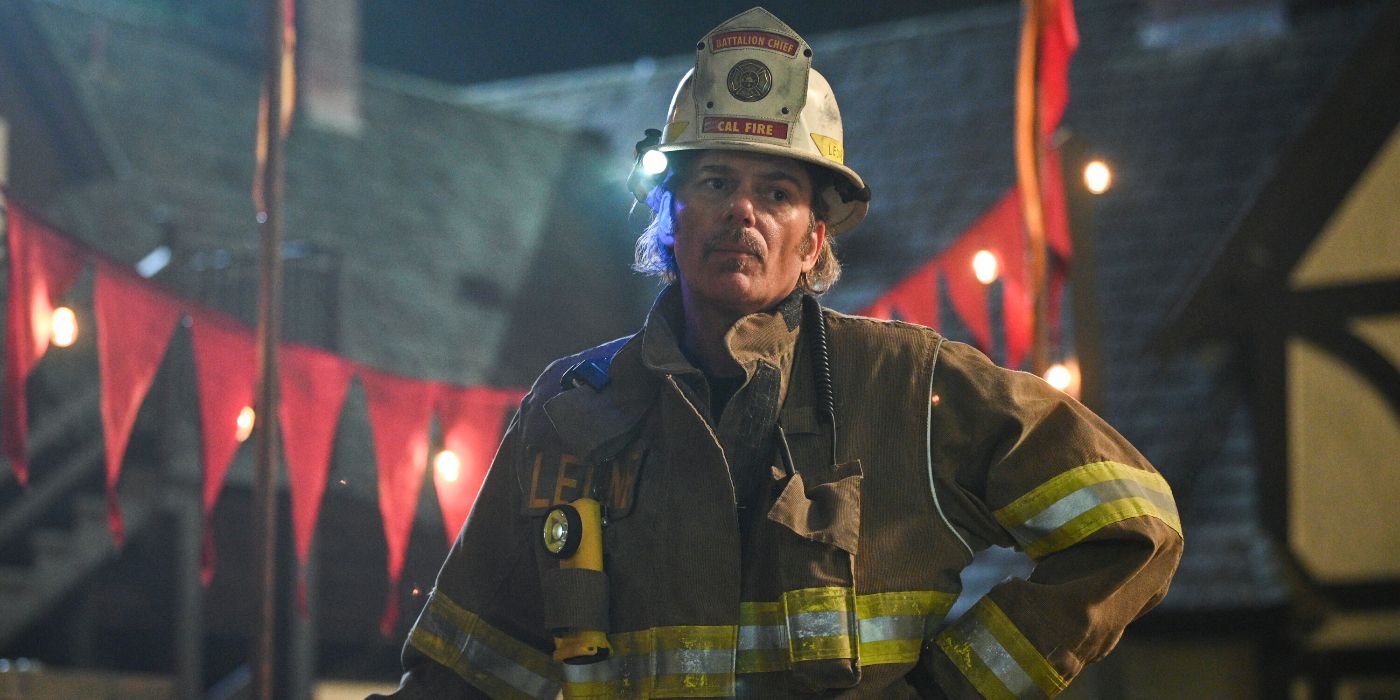 Billy Burke with a hand on hip while wearing his firefighting gear
