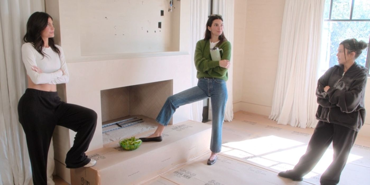 Kylie Jenner, Kendall Jenner, and Kourtney Kardashian stand in a half circle with their arms crossed in front of a fireplace on &lsquo;The Kardashians&rsquo;