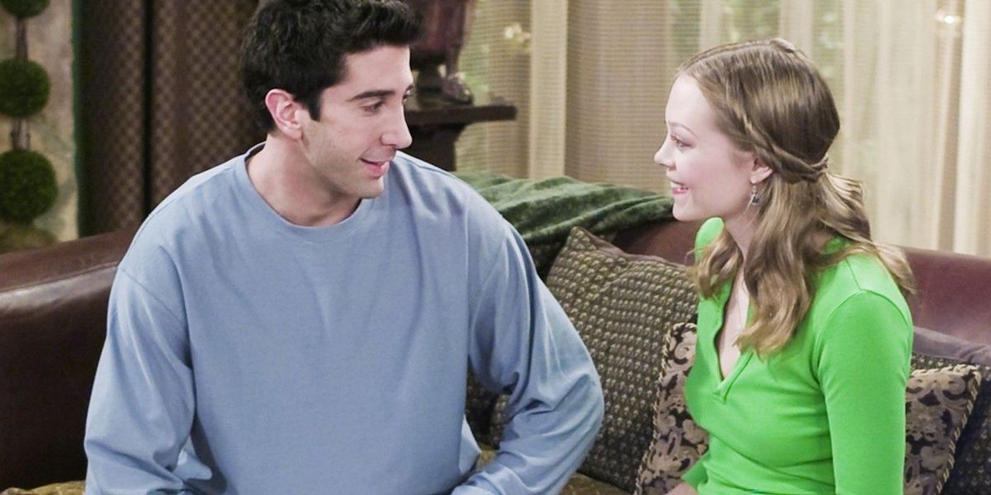 Ross and his girlfriend sit on a couch talking in Friends