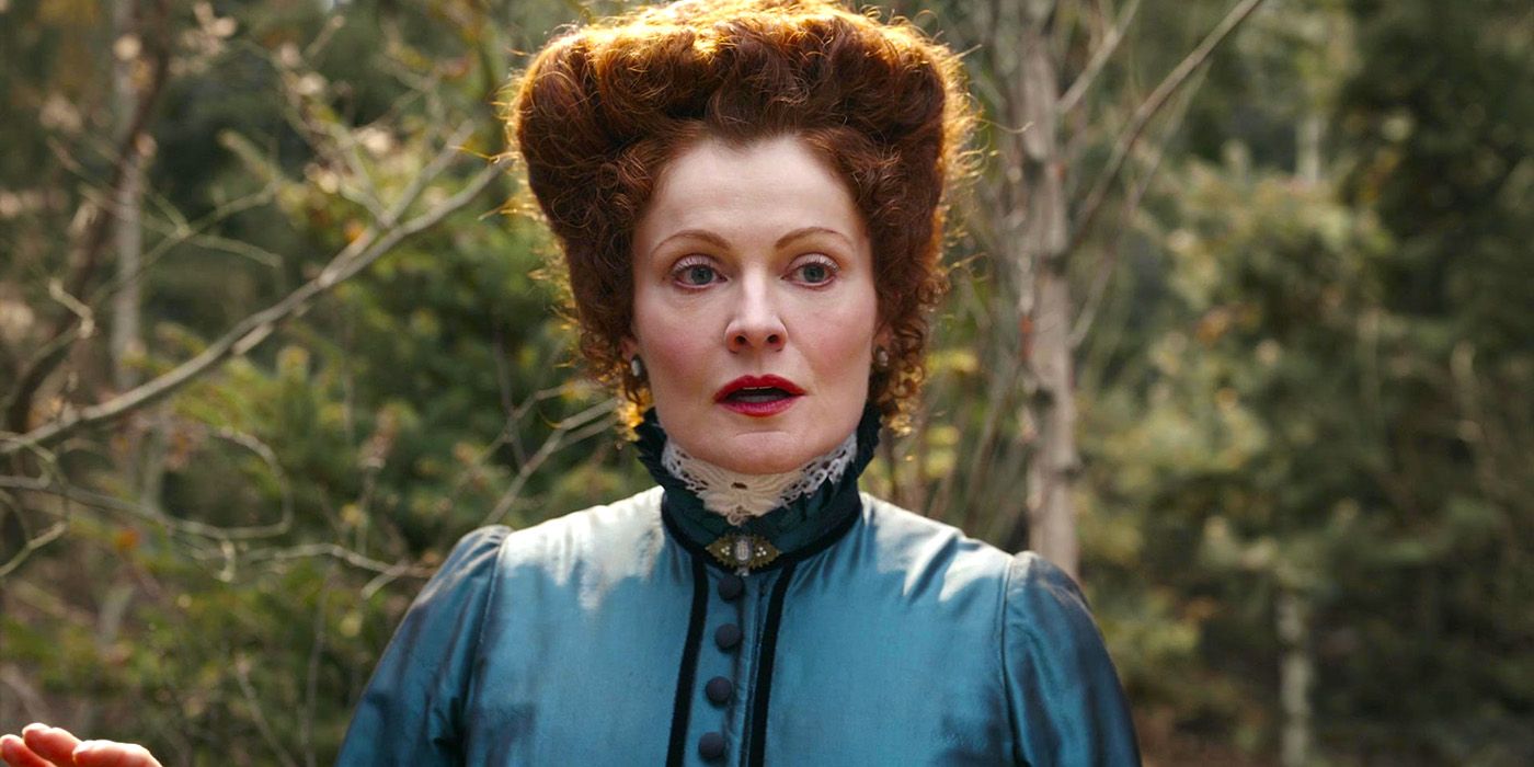 Hetty looks upset, standing in front of trees in the US TV series Ghosts, Season 3.