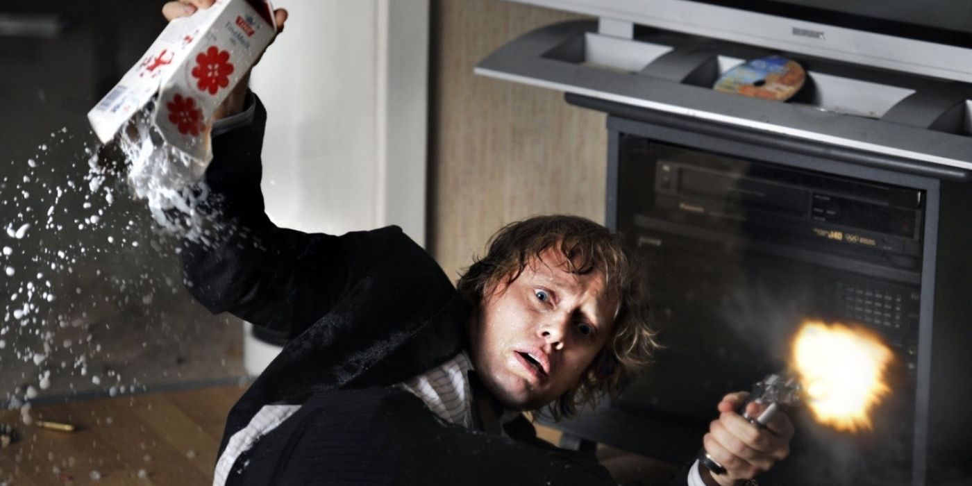 A startled man fires a weapon as he falls to the ground with a carton of spilling milk