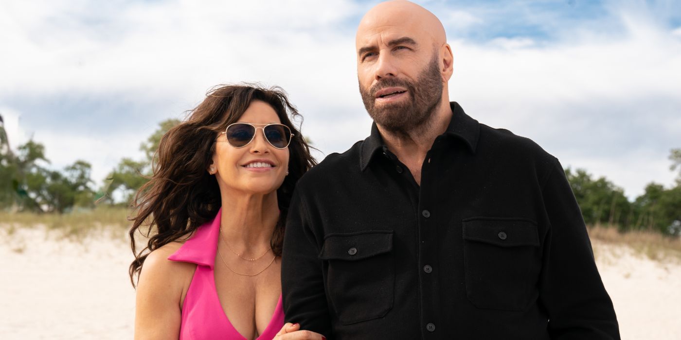 Gina Gershon and John Travolta walk along a beach in an image from 'High Rollers'