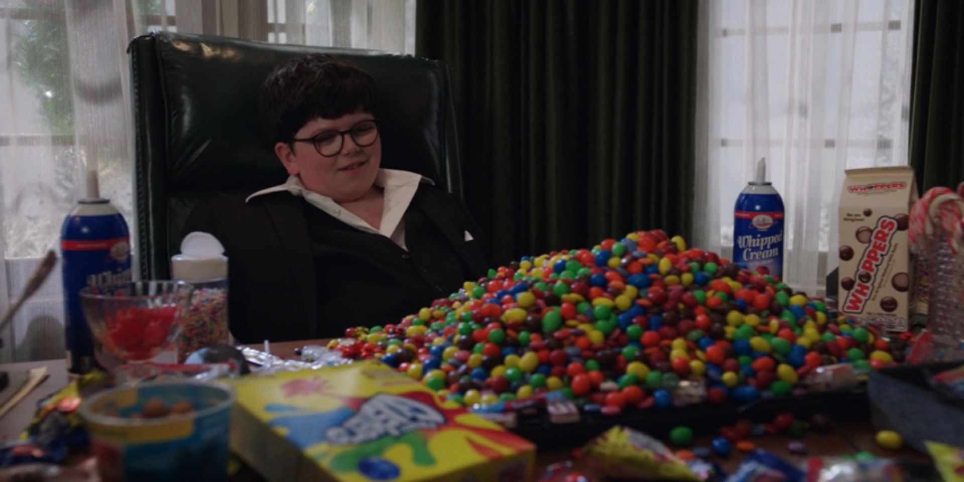 Max Mercer, played by Archie Yates, looks at a big pile of candy in 'Home Sweet Home Alone'.