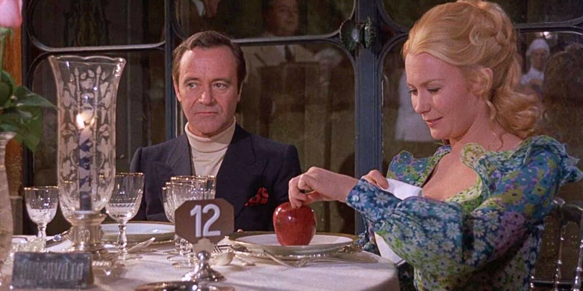 Jack Lemmon sitting at a table next to Juliet Mills who is looking at an apple on her plate in front of her in Avanti! (1972)