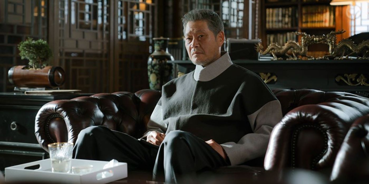 Yoo Jae-myung sitting on a leather couch and looking pensively in front of him in Itaewon Class.