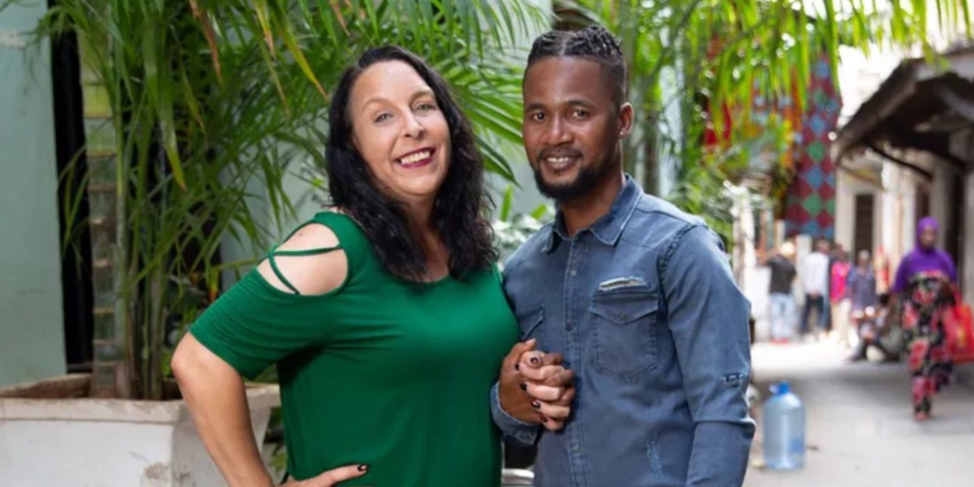 Kim Menzies and Usman Umar hold hands and smile, standing outside on &lsquo;90 Day Fiance&rsquo;.
