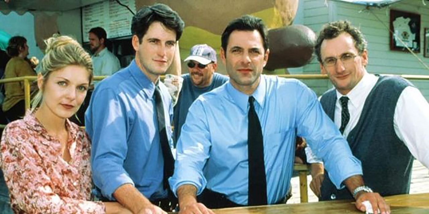 Three men in suits and a woman in a floral shirt pose from L.A. Doctors
