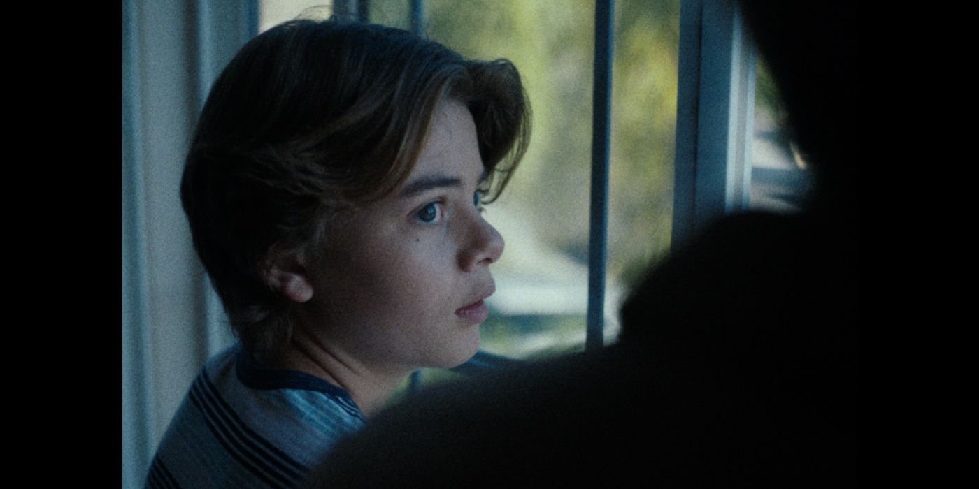 Brecken Merrill as Young Steven looking out of a window in flashback in Lifeline.