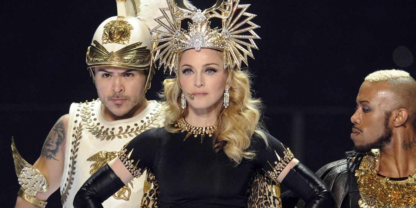 Madonna wearing a gold crown staring straight ahead at the 2012 Super Bowl