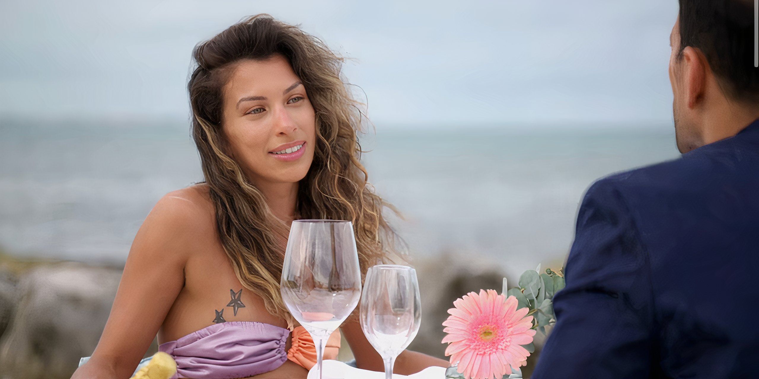 Karla Juarez sitting at a table by the beach in Married at First Sight