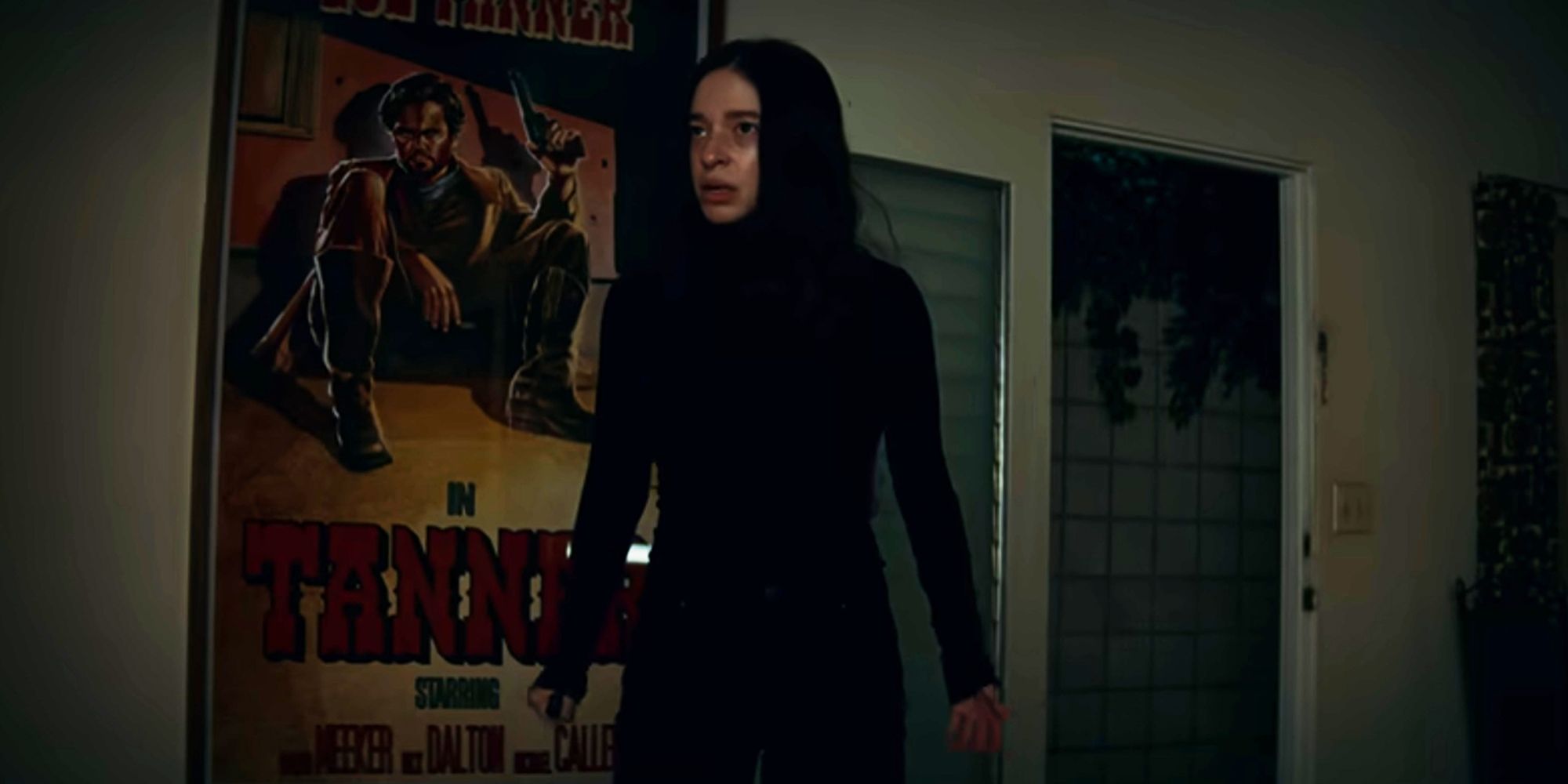 Mikey Madison as Sadie standing in a room with posters looking serious in Once Upon A Time... In Hollywood.