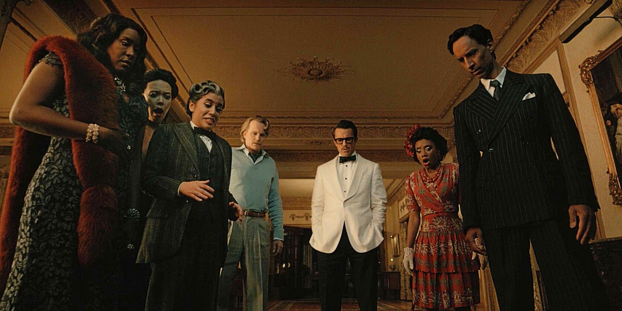 Carol, Poppy, Rachel, David, Ian, Dana, and Brad looking at the floor during a murder mystery party in Mythic Quest Season 4