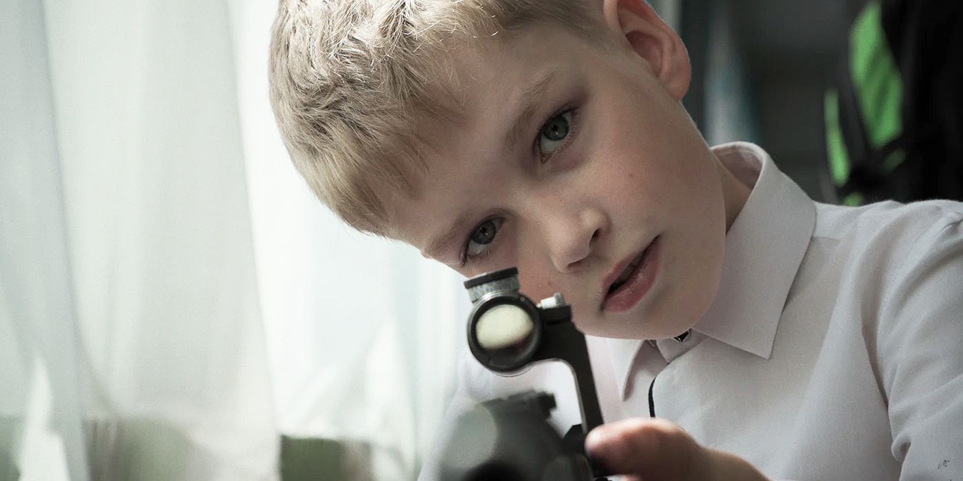 A child holding a gun and looking through the rifle scope in Mr. Nobody Against Putin